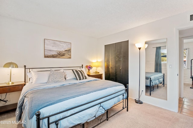 carpeted bedroom featuring a closet, visible vents, a textured ceiling, and baseboards