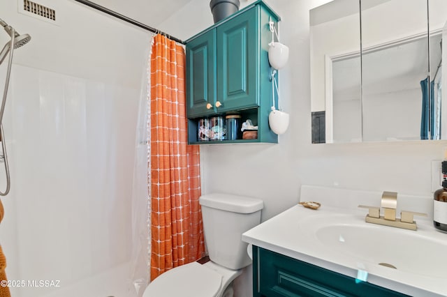 bathroom featuring visible vents, vanity, toilet, and a shower stall