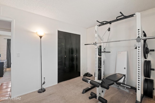 exercise area with a textured ceiling and carpet floors