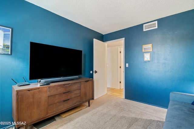 living room featuring light colored carpet, visible vents, and a textured ceiling