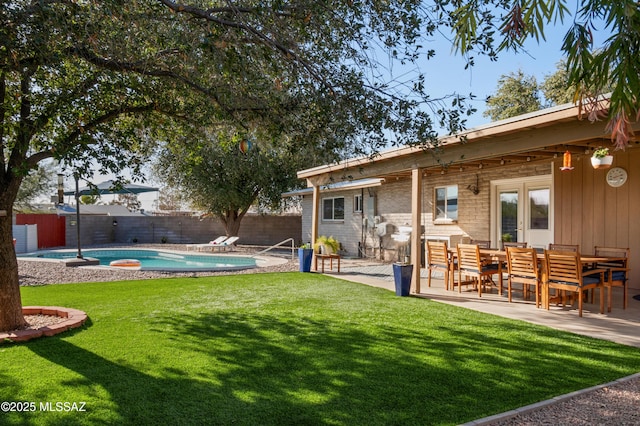 view of yard with a fenced in pool, a patio, french doors, and a fenced backyard