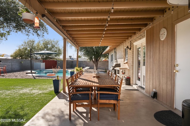 view of patio / terrace featuring outdoor dining area, a fenced in pool, a fenced backyard, and french doors