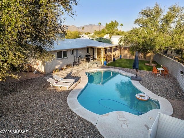 view of swimming pool with a fenced in pool, a lawn, a fenced backyard, a mountain view, and a patio