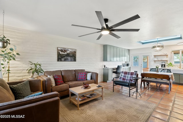 living room featuring light tile patterned flooring, brick wall, and a ceiling fan