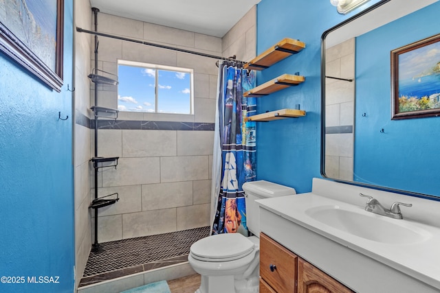 full bath featuring vanity, toilet, and a stall shower