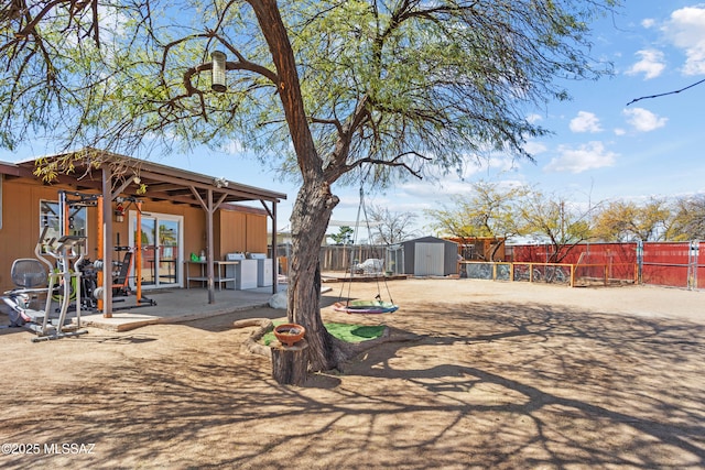 view of yard with a storage unit, a patio area, an outdoor structure, and a fenced backyard