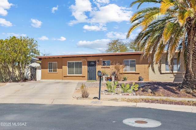 ranch-style home with concrete driveway