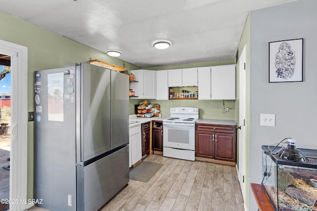 kitchen featuring light wood-style flooring, electric stove, open shelves, freestanding refrigerator, and light countertops