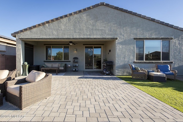 back of property featuring a patio area, ceiling fan, an outdoor living space, and stucco siding