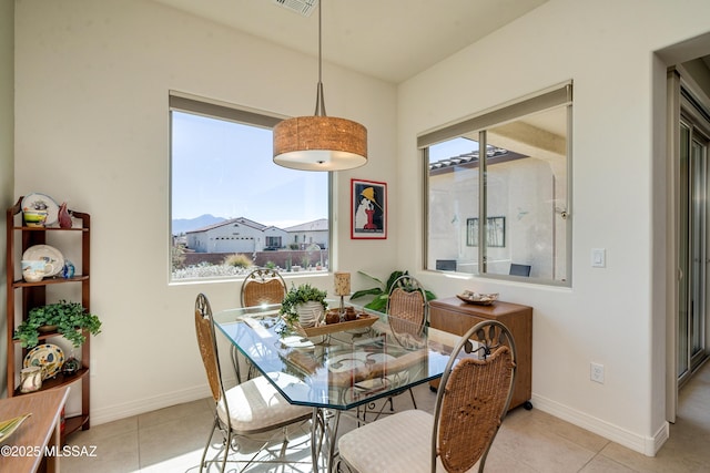 dining room featuring light tile patterned flooring, visible vents, and baseboards