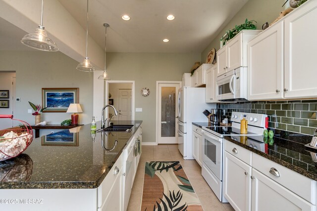 kitchen featuring light tile patterned floors, white appliances, a sink, white cabinets, and backsplash