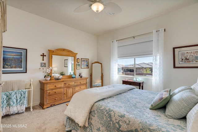 carpeted bedroom with ceiling fan and baseboards