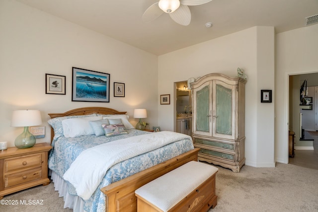 bedroom featuring light carpet, visible vents, baseboards, ceiling fan, and ensuite bathroom