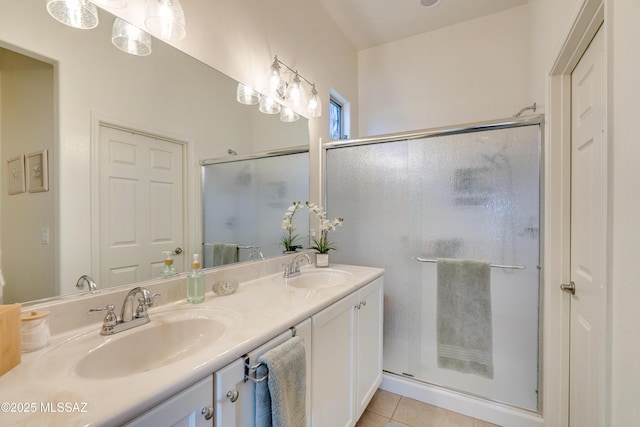 bathroom with tile patterned flooring, a sink, a shower stall, and double vanity