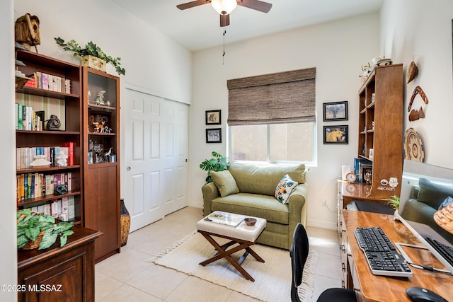 living room featuring baseboards, a ceiling fan, and light tile patterned flooring