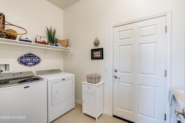 laundry area featuring laundry area, baseboards, light tile patterned flooring, and independent washer and dryer