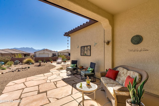 view of patio / terrace with a fenced backyard, a mountain view, and an outdoor living space