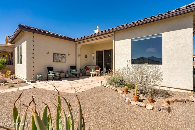 rear view of house featuring a patio and stucco siding