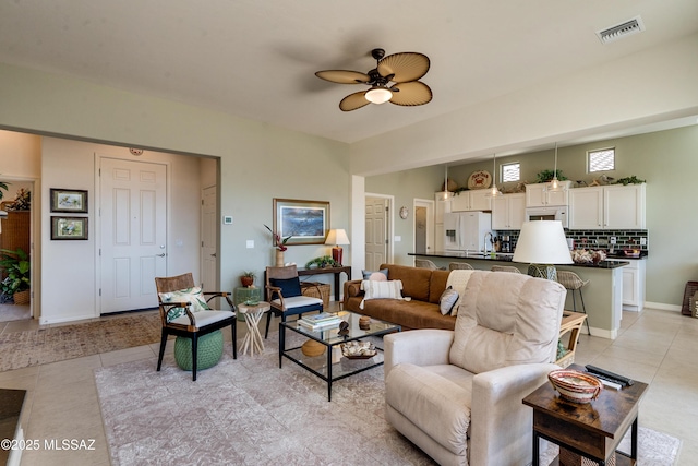 living area featuring ceiling fan, visible vents, baseboards, and light tile patterned flooring