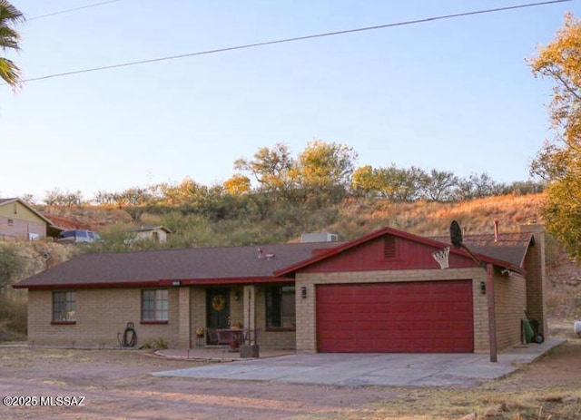 ranch-style house with brick siding, an attached garage, and driveway