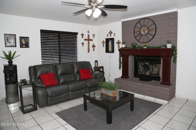 tiled living room featuring a brick fireplace and a ceiling fan