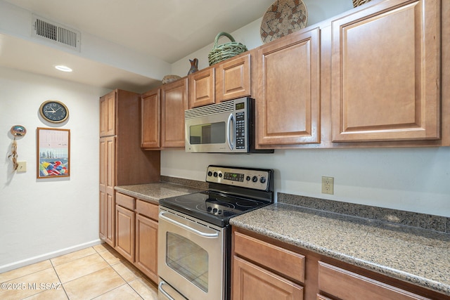 kitchen with light tile patterned flooring, visible vents, baseboards, appliances with stainless steel finishes, and brown cabinetry