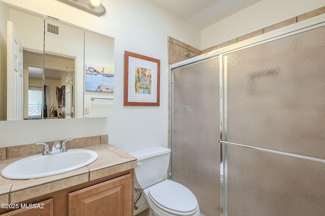 full bath featuring toilet, a shower stall, and vanity