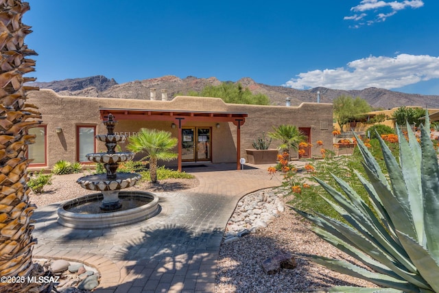 rear view of property featuring french doors, a mountain view, and a patio