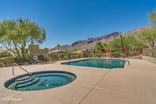 pool with a patio, a community hot tub, fence, and a mountain view