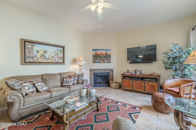 living area featuring light tile patterned floors, ceiling fan, and a fireplace