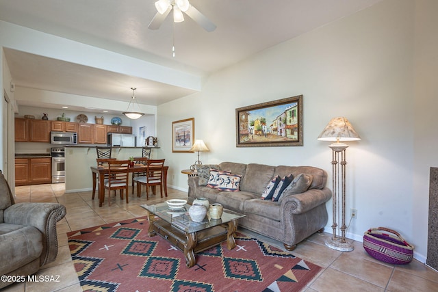 living room featuring a ceiling fan, light tile patterned flooring, and baseboards