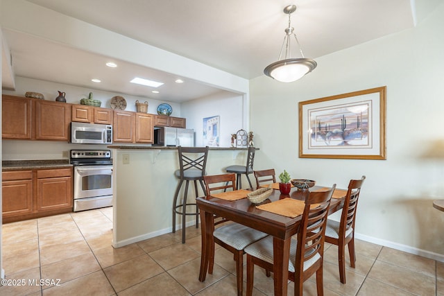 dining area with light tile patterned floors, baseboards, and recessed lighting