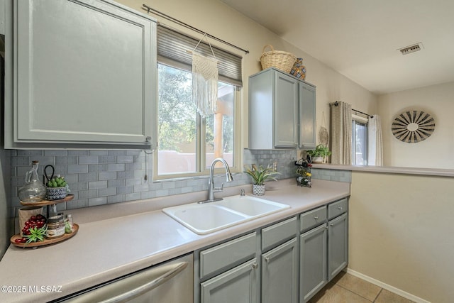 kitchen featuring visible vents, backsplash, a sink, light countertops, and stainless steel dishwasher