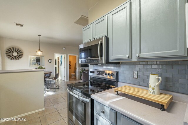 kitchen with light tile patterned floors, visible vents, appliances with stainless steel finishes, and decorative backsplash