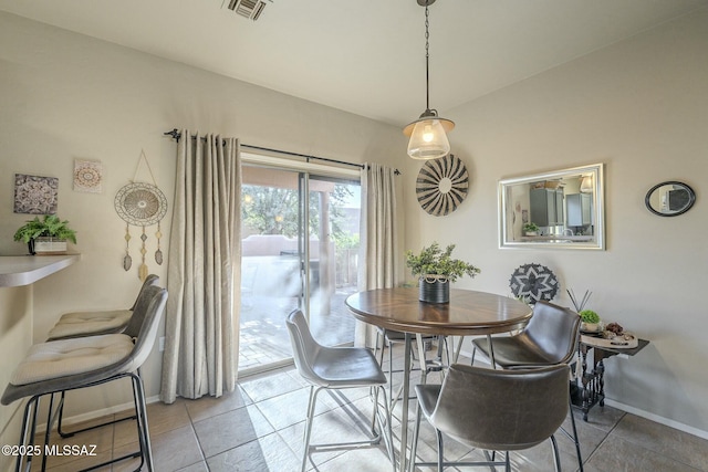 dining space featuring baseboards, visible vents, and light tile patterned flooring