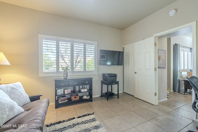 living area with baseboards and light tile patterned floors