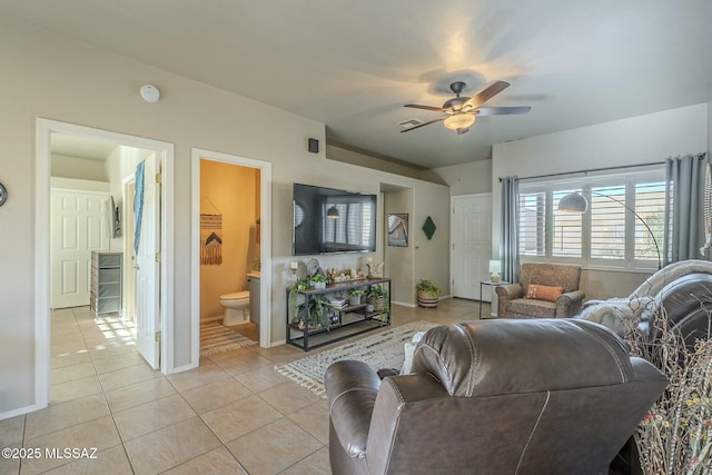 living area featuring a ceiling fan, baseboards, and light tile patterned floors