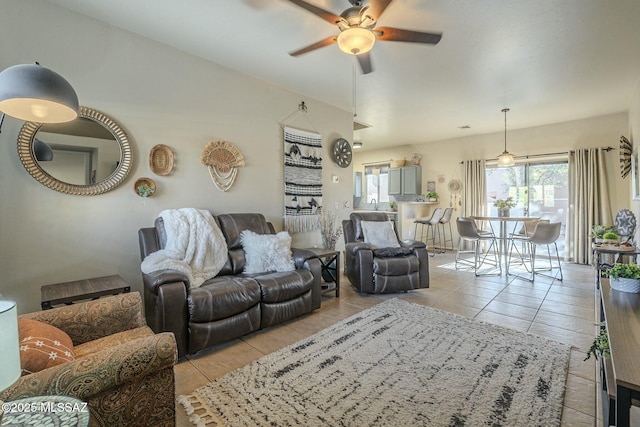 living area with light tile patterned floors and a ceiling fan