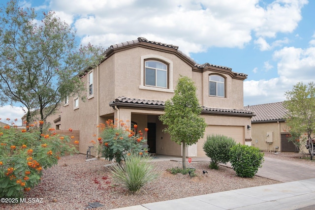 mediterranean / spanish-style house featuring a garage, decorative driveway, a tile roof, and stucco siding