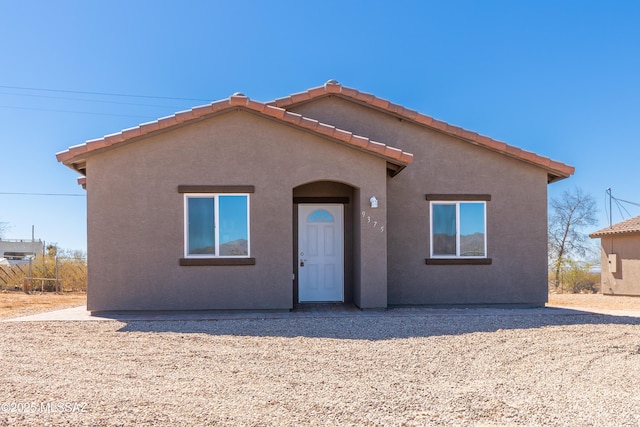 view of front of house with a tiled roof and stucco siding