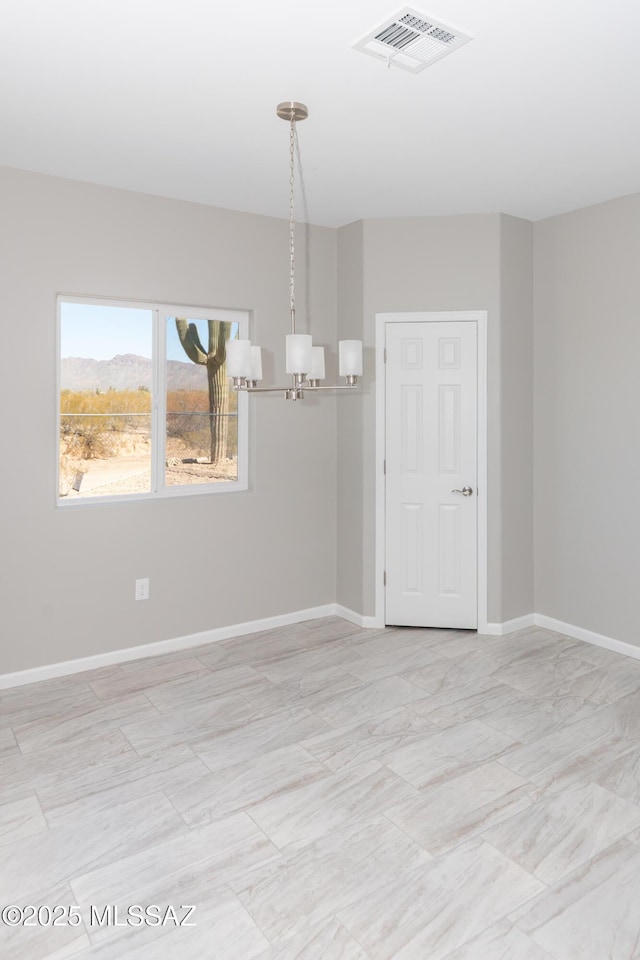 unfurnished room featuring a chandelier, visible vents, and baseboards