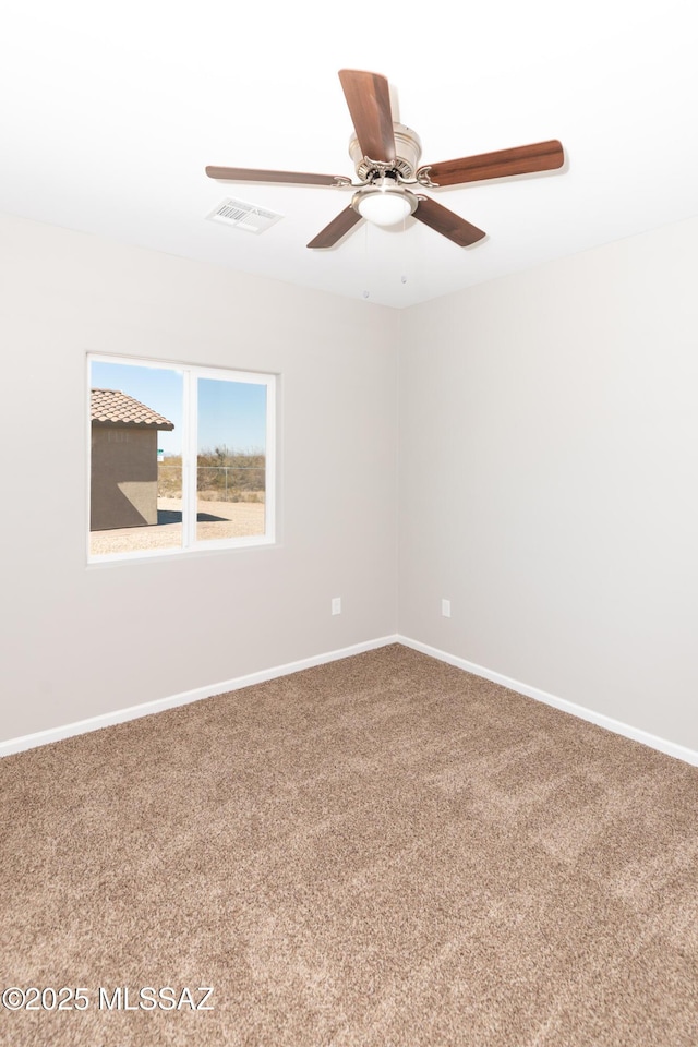 carpeted empty room with visible vents, baseboards, and a ceiling fan