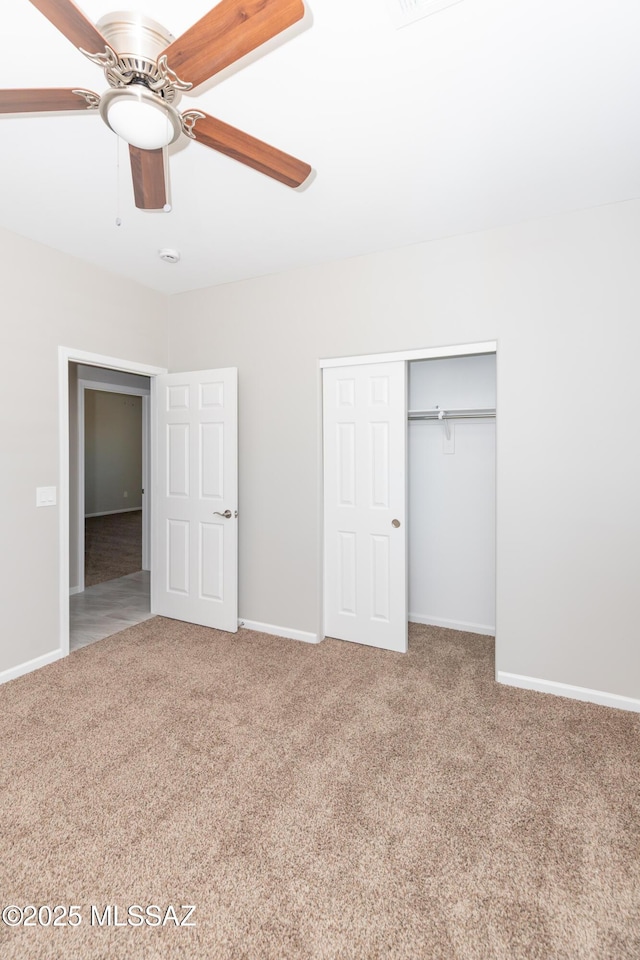 unfurnished bedroom with carpet flooring, a closet, baseboards, and a ceiling fan