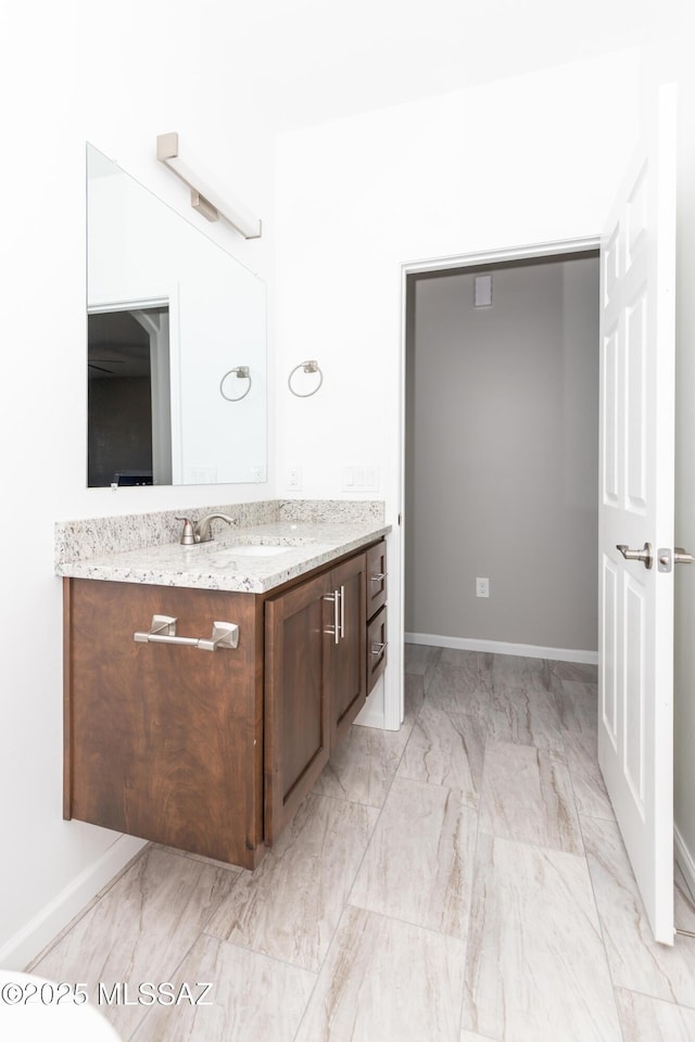 bathroom with baseboards, marble finish floor, and vanity