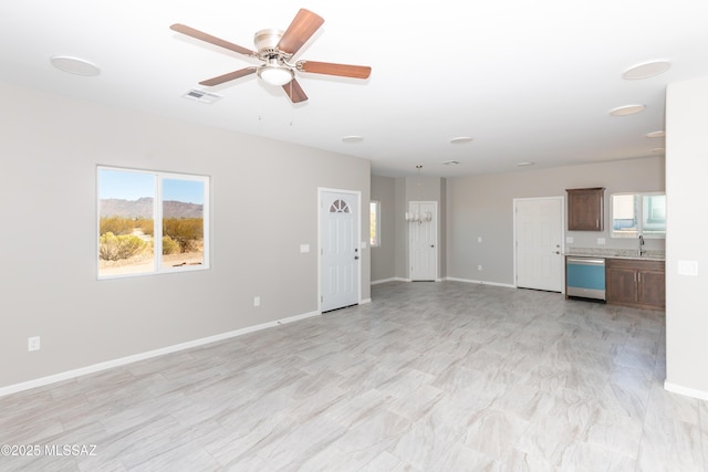 unfurnished living room with a ceiling fan, baseboards, visible vents, and a sink