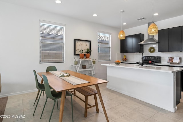 kitchen with dark cabinets, light countertops, backsplash, visible vents, and pendant lighting