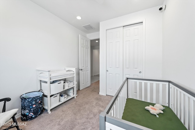 carpeted bedroom featuring visible vents, recessed lighting, and a closet