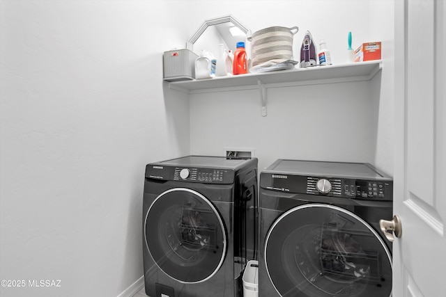 laundry room with baseboards, washer and clothes dryer, and laundry area