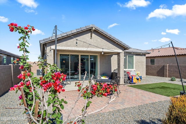 back of property featuring stucco siding, a patio, and a fenced backyard