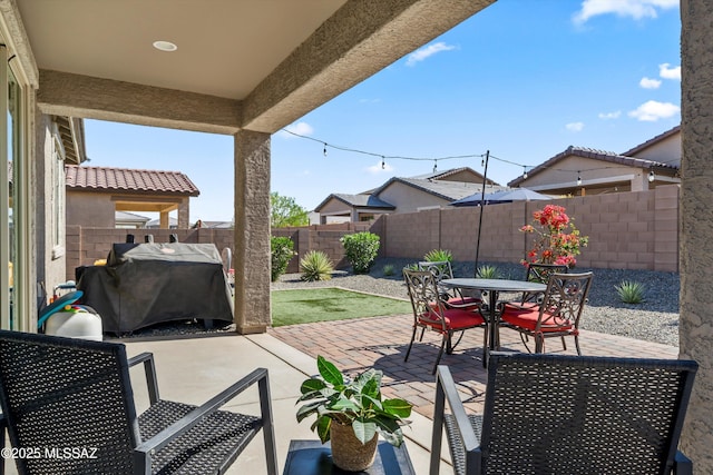 view of patio / terrace featuring a grill, a fenced backyard, and outdoor dining space